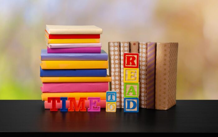 Stack of books on a wooden table against a blurred background