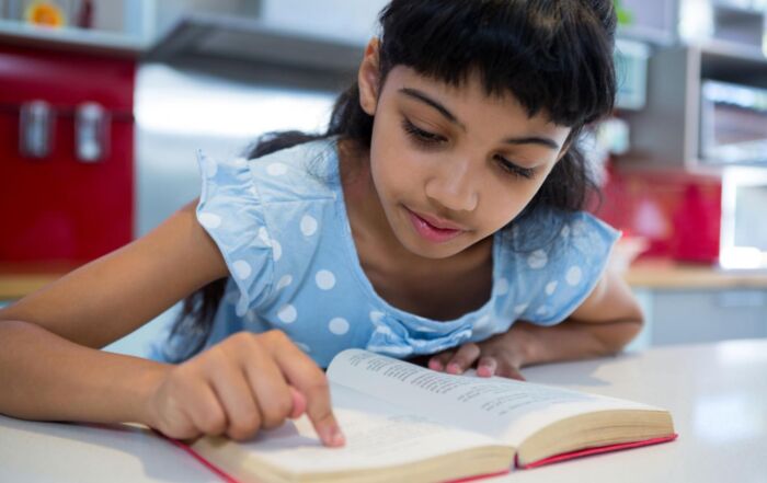 Young girl reading, highlighting the advantages of Structured Literacy education.